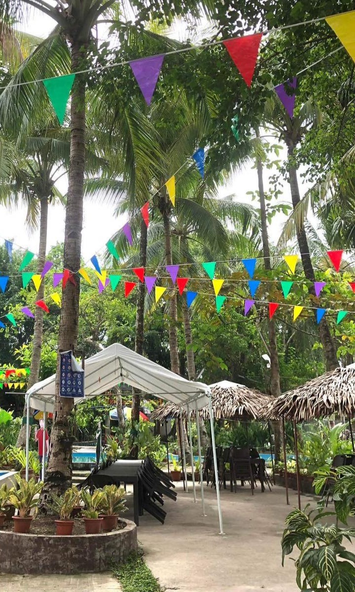 An event set up under the trees with buntings and tents