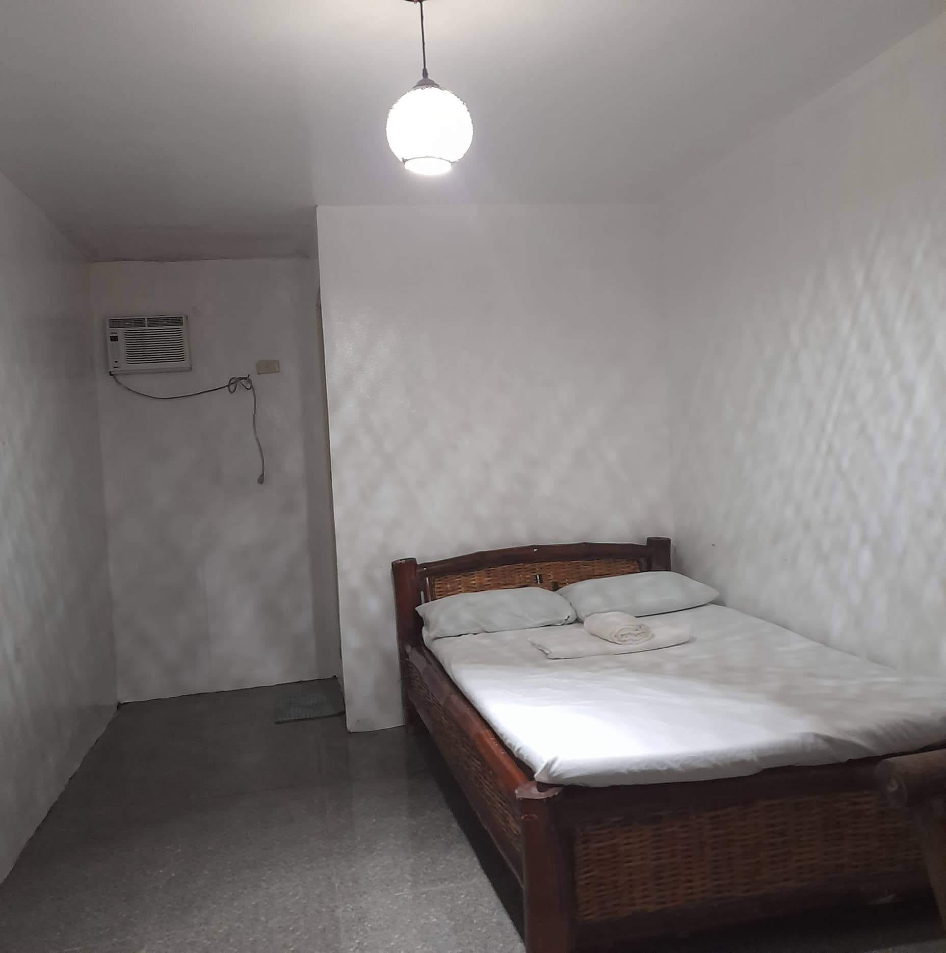 Air-conditioned room with a double bed and wicker frame