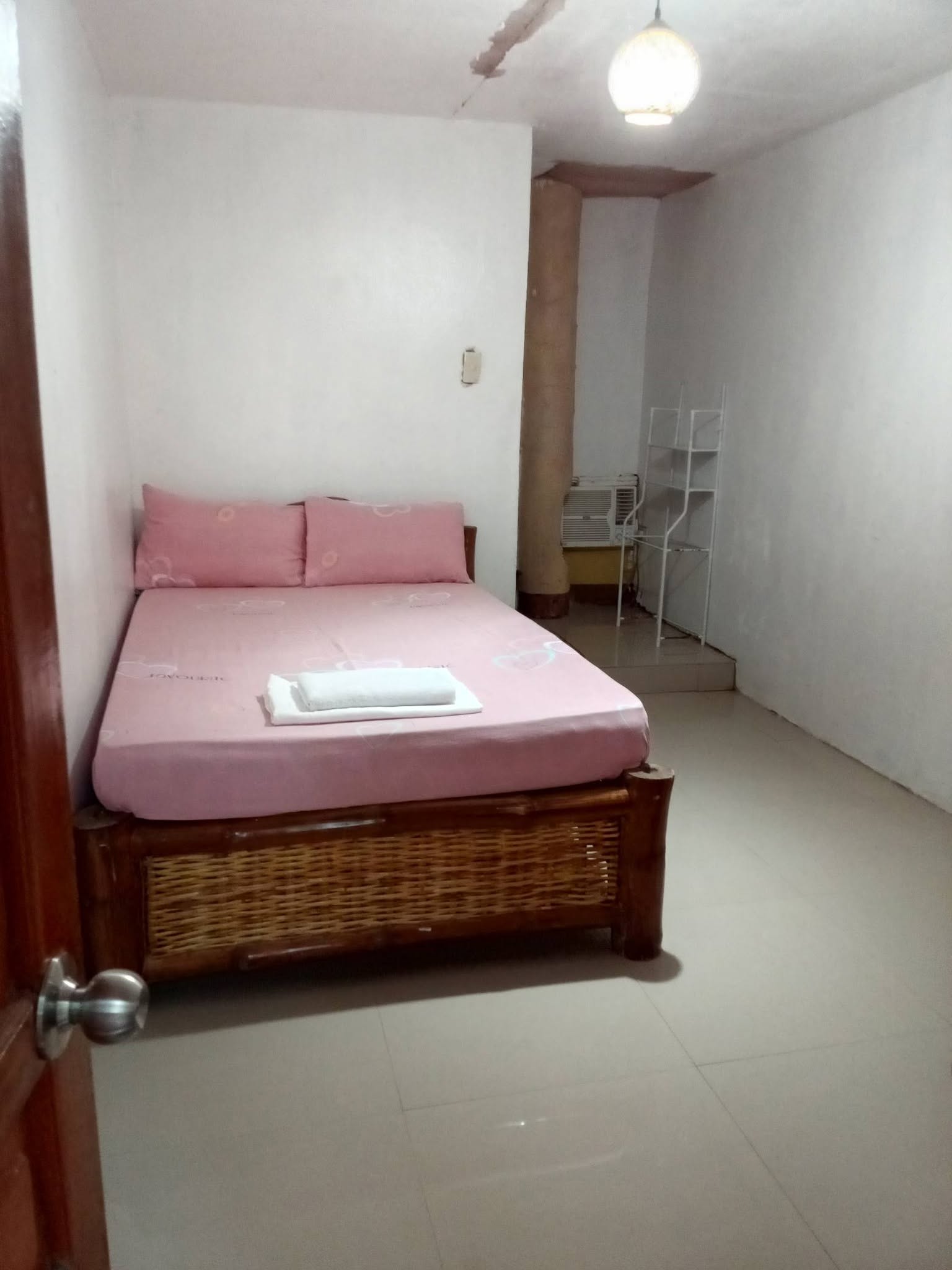 Room with a double bed, air-conditioning, and shelving